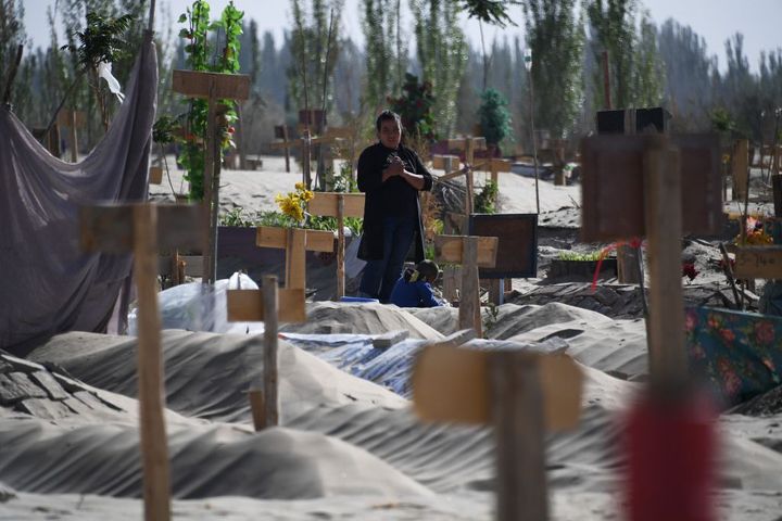 This photo taken on May 31, 2019, shows a woman in a Uighur graveyard on the outskirts of Hotan in China's northwest Xinjiang