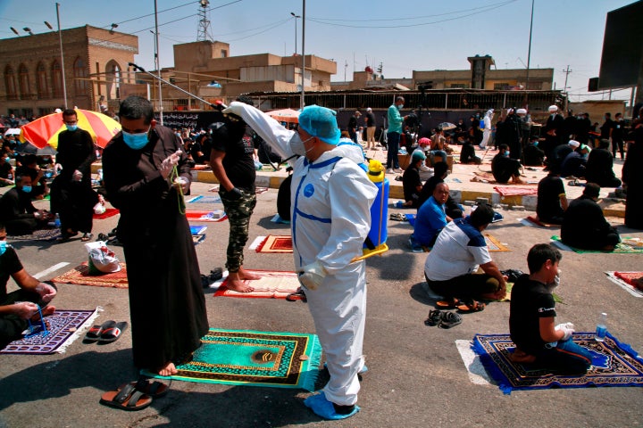 A volunteer sprays disinfectant as a precaution against the coronavirus during Friday prayers in Baghdad, Iraq, on Sept. 11, 