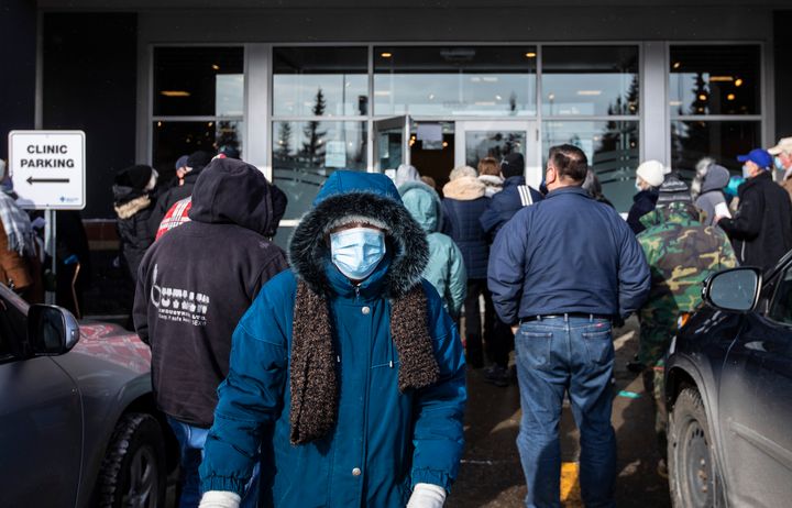 People line up outside a vaccine clinic as seniors wait to get the COVID-19 vaccine in Edmonton, Alta., on Feb. 26, 2021.