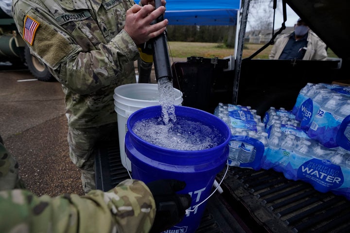 Mississippi Army National Guard Sgt. Chase Toussaint fills five-gallon buckets with nonpotable water at the New Mt. Zion Miss