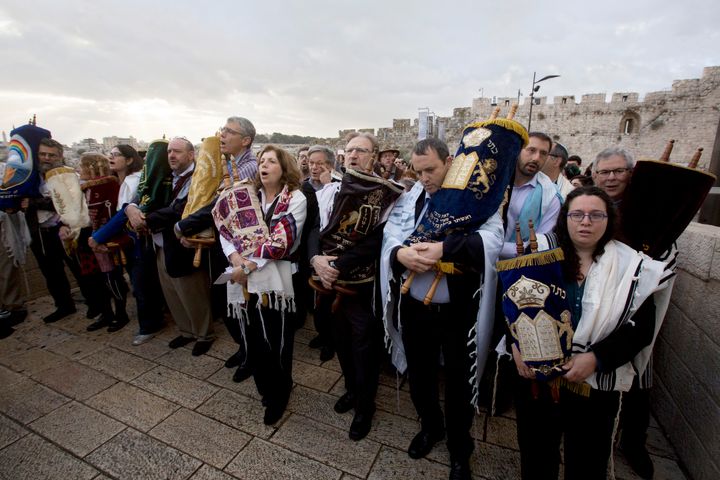 The heads of the Jewish Reform and Conservative movements carry Torah scrolls as they march to the Western Wall in Jerusalem's Old City in 2016. Israel's Supreme Court on Monday bucked Israel's powerful Orthodox establishment when it ruled that people who convert to Judaism through the Reform and Conservative movements in Israel also are Jewish and entitled to become citizens.