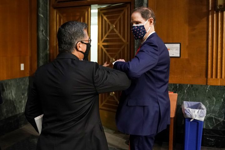 Senate Finance Committee Chairman Ron Wyden (D-Ore.), right, bumps elbows Thursday with Xavier Becerra, nominee for secretary of health and human services, after Becerra's confirmation hearing.