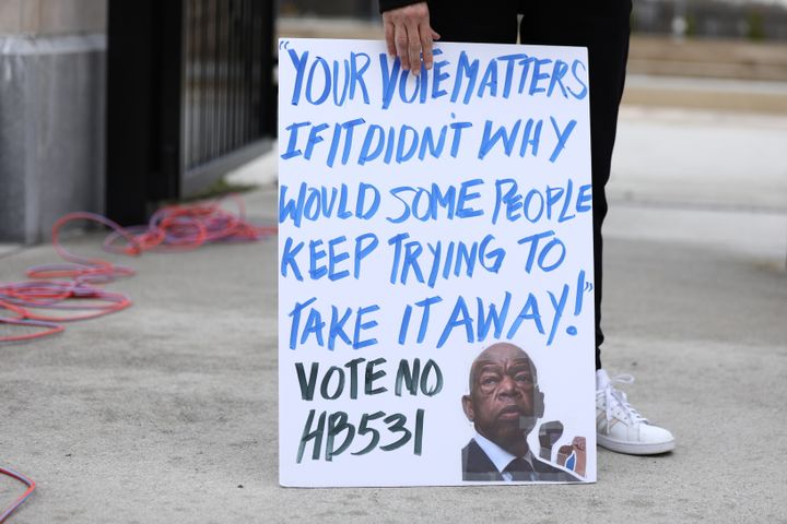 A person holds a placard outside the Georgia state Capitol in Atlanta to protest HB 531, March 1, 2021.