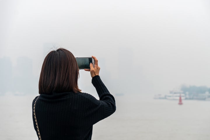 A tourist takes photos of the haze in Shanghai, China, on Dec. 24, 2020.