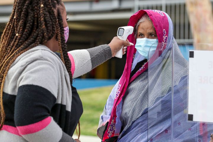 Jaimie Mitchell, left, screens Fulerun Begum at a vaccination site opened by St. John's Well Child and Family Center at East Los Angeles Civic Center on March 3, 2021 in Los Angeles.