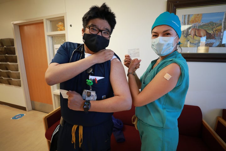 Lance Whitehair (left), a Navajo doctor, and Bijiibaa' Kristin Garrison, a Navajo surgeon, pose for photos after receiving their COVID-19 vaccines at Northern Navajo Medical Center on December 15, 2020, in Shiprock, New Mexico. Medical staff at the Northern Navajo Medical Center are among the first in the Navajo Nation to receive the Pfizer vaccination.