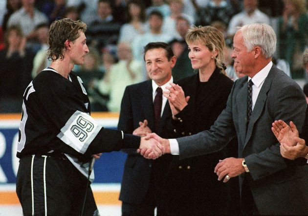 Los Angeles Kings forward Wayne Gretzky shakes hands with Gordie Howe, right, during a ceremony celebrating his breaking Howe's record of 1,850 career points Oct. 15, 1989, while father Walter watches in the background.