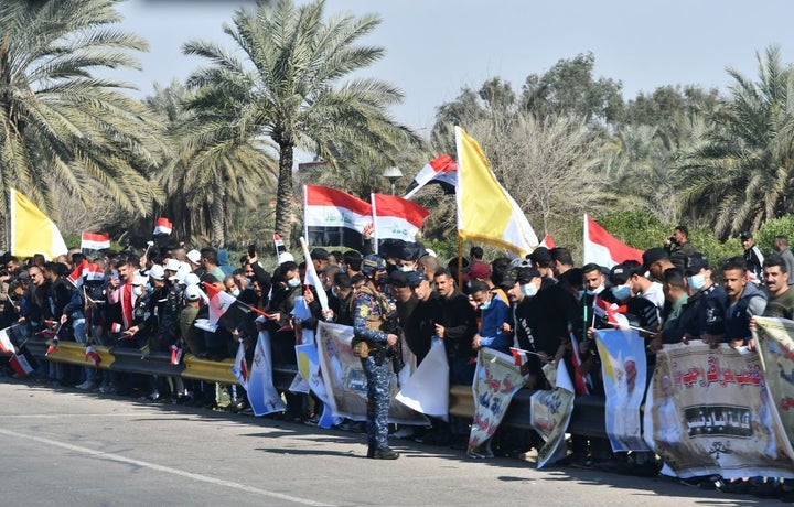 Iraqis line up along the road leading to Baghdad airport as they welcome the pontiff upon his arrival.