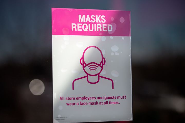 A sign about COVID-19 restrictions inside a T-Mobile store in Austin, Texas. Gov. Greg Abbott announced this week that the state will end its mask mandate and allow businesses to reopen at 100% capacity on March 10. 