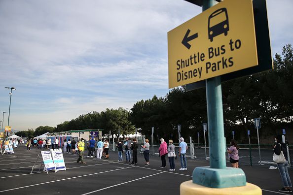 People wait in line to receive the COVID-19 vaccine at a mass vaccination site in a parking lot for Disneyland Resort on January 13, 2021 in Anaheim, California. Disneyland and other theme parks in the state will be allowed to reopen on April 1.