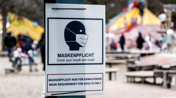 A sign that says "mask requirement" hangs at the entrance to a public playground in Hamburg, Germany, in February. In certain areas and at certain times, masks are required outdoors in the city.
