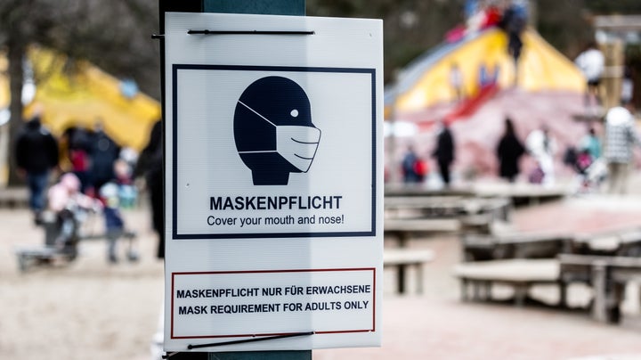 A sign that says "mask requirement" hangs at the entrance to a public playground in Hamburg, Germany, in February. In certain