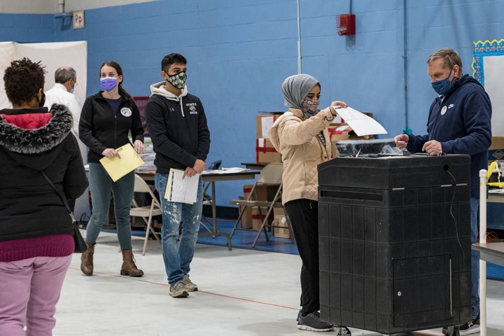 First-time voter Marwah Al Thuwayni, 18, casts a ballot at the Bishop Leo E. O'Neil Youth Center polling place in Manchester, New Hampshire, Nov. 3, 2020.