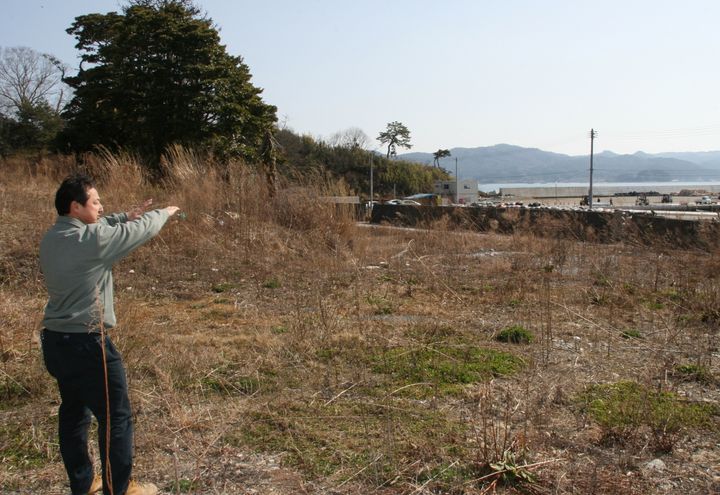 津波が来るまで経営した民宿「向」の跡地を案内する佐々木昌則さん（2015年撮影）