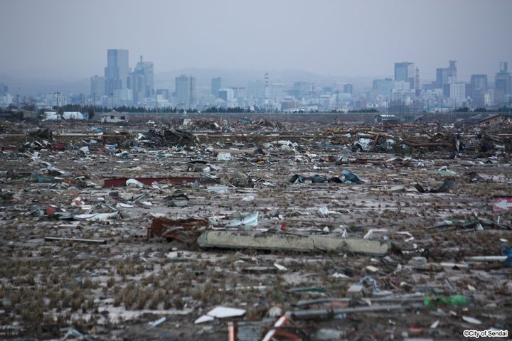 津波で建物がほぼ消失した荒浜地区から見えた仙台市中心部のビル群（2011年3月23日、仙台市提供）
