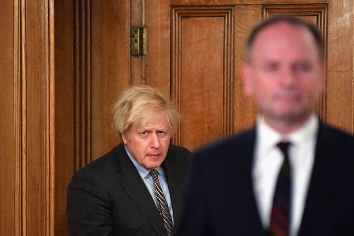 Boris Johnson arrives with Sir Simon Stevens, Chief Executive of the National Health Service, for a media briefing in Downing Street