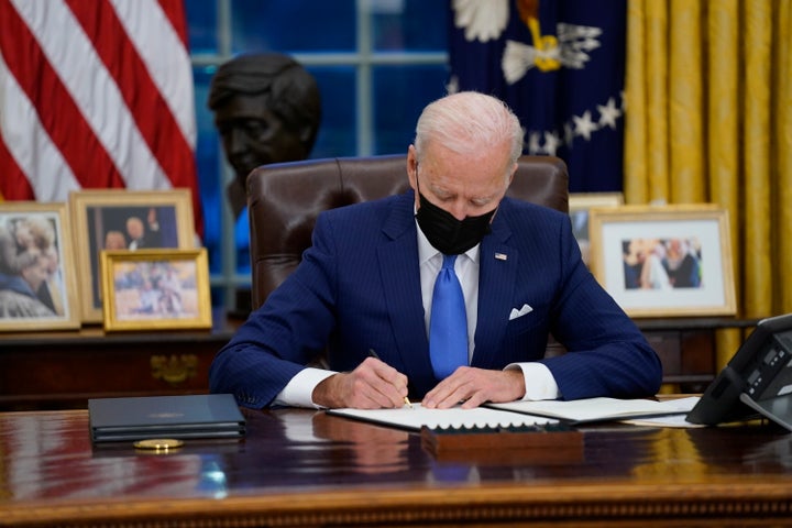 President Joe Biden signs an executive order on immigration in the Oval Office of the White House, Feb. 2, 2021.