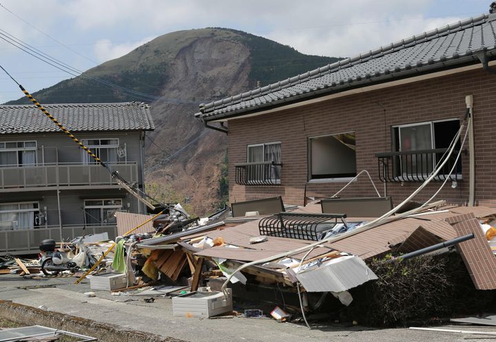 地震で倒壊した東海大阿蘇キャンパス周辺のアパートと土砂崩れした山＝2016年4月22日、熊本県南阿蘇村