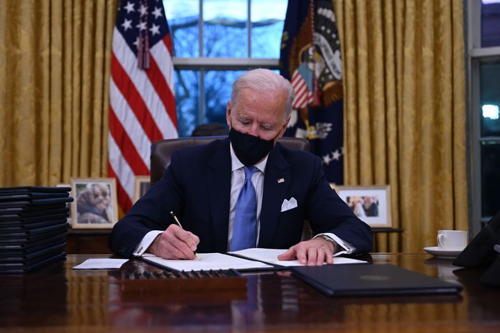 President Joe Biden signs a series of orders after being sworn in as president on Jan. 20, including one that rescinded Donald Trump's travel ban.