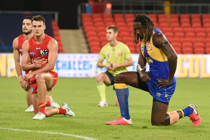 Nic Naitanui, right, of West Coast Eagles takes a knee in support of the Black Lives Matter movement before the Round 2 AFL match between the Gold Coast Suns and the West Coast Eagles at Metricon Stadium on June 13, 2020, in Gold Coast, Australia.