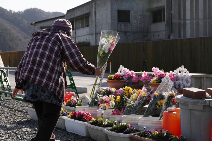 石巻市立大川小学校の被災校舎前で、献花台に花を手向ける女性 撮影日：2021年03月11日