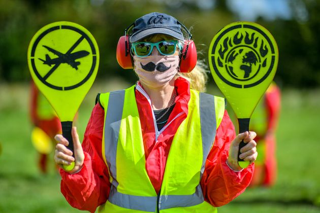 Activists from Extinction Rebellion, dressed as aircraft marshals, as they take part in a protest against the plan to expand Bristol International Airport in August, 2020.