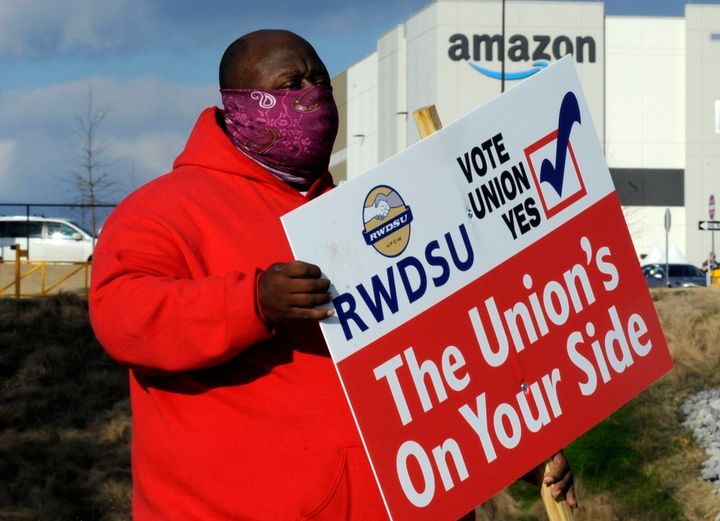 Michael Foster of the Retail, Wholesale and Department Store Union holds a sign outside an Amazon facility, Feb. 9.