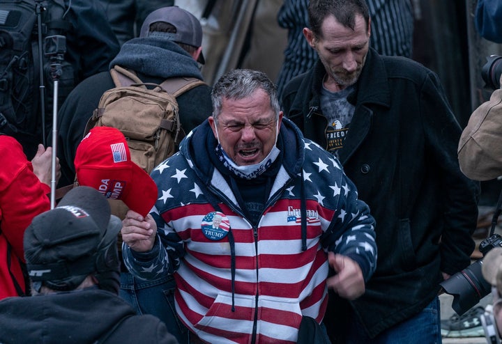 HuffPost identified Robert Scott Palmer (center) as a member of the pro-Trump crowd that stormed the U.S. Capitol on Jan. 6. He was filmed assaulting police with a fire extinguisher.