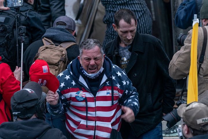 HuffPost identified Robert Scott Palmer (center) as a member of the pro-Trump crowd that stormed the U.S. Capitol on Jan. 6. He was filmed assaulting police with a fire extinguisher.