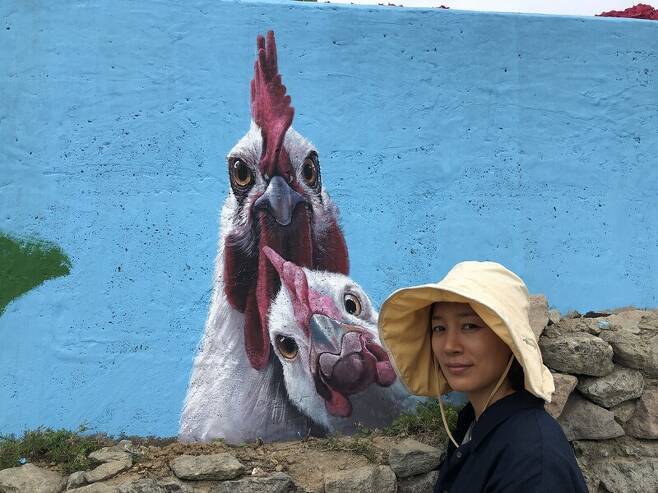 도초 수국공원’ 돌담 벽화 앞에 선 김지안 작가