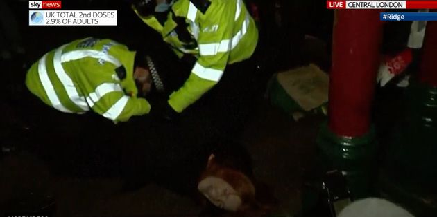 Police officers hold down a woman attending the Sarah Everard vigil