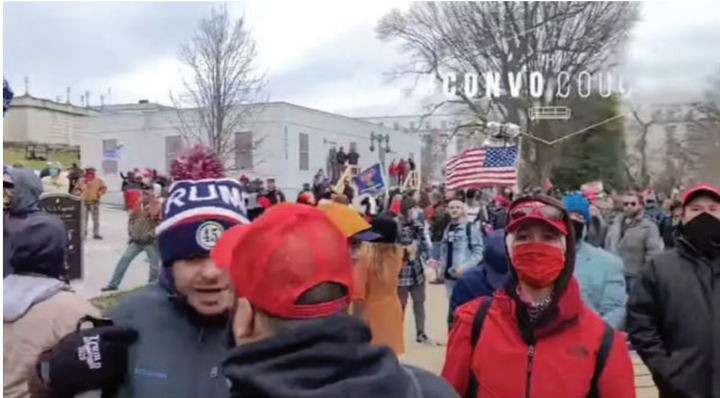 Julian Khater, wearing a beanie with a pom-pom, can be seen speaking to George Tanios, wearing a red hat, in this still from video obtained by the FBI.