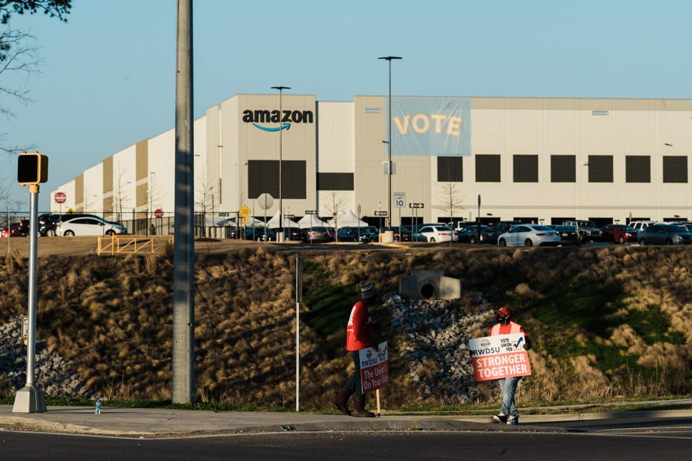 Union organizers from the Retail, Wholesale, and Department Store Union rally support as workers change shifts outside Amazon