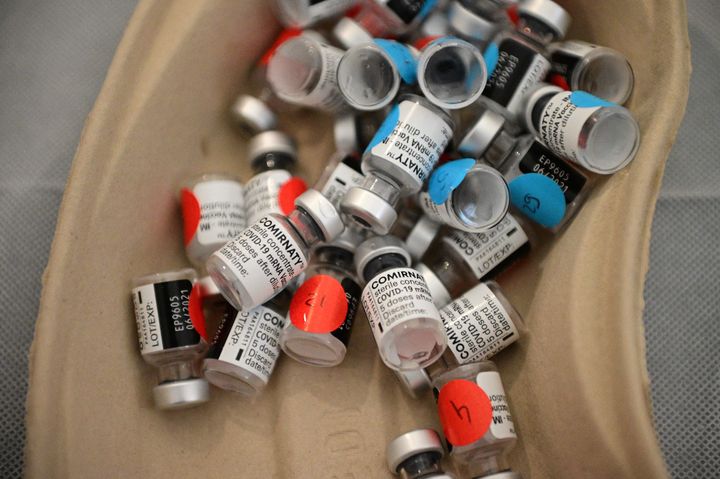 Empty vaccination vials are placed in a tray after being used during a vaccination drive against Covid-19 in Paris.