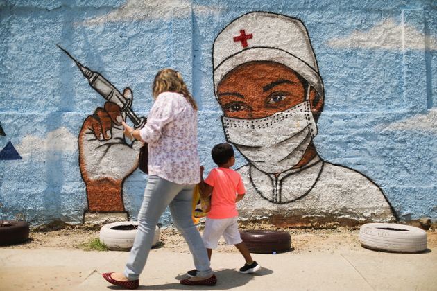 (photo d'illustration d'un enfant passant devant un dessin de street-art, prise au Brésil, à Rio de Janeiro en mars 2021)