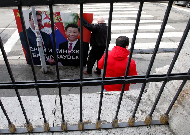Ένας άντρας κρατά ένα πανό με φωτογραφία του Σέρβου προέδρου Αλεξάνταρ Βούτσιτς, αριστερά και του προέδρου της Κίνας Σι Τζινπίνγκ, όπου γράφει το σύνθημα: "Σέρβοι και Κινέζοι αδελφοί για πάντα", Παρασκευή, 19 Φεβρουαρίου 2021. (AP Photo/Darko Vojinovic)
