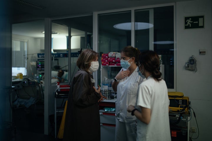 Un mujer conversa con dos sanitarias en el hospital
