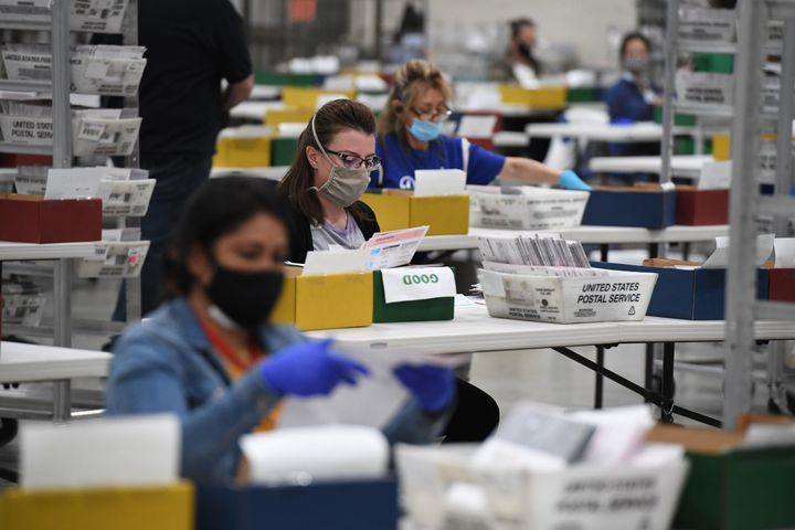 Election workers extract mail-in ballots from their envelopes and examine the ballot for irregularities at the Los Angeles County Registrar Recorders' mail-in ballot processing center at the Pomona Fairplex in Pomona, California, Oct. 28, 2020.