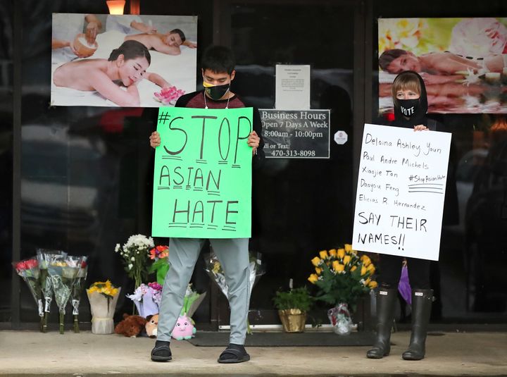 After dropping off flowers Jesus Estrella, left, and Shelby stand in support of the Asian and Hispanic community outside Young's Asian Massage Wednesday, March 17, 2021, in Acworth, Ga. (Curtis Compton /Atlanta Journal-Constitution via AP)