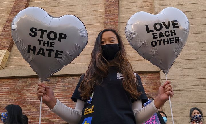 In this March 13, 2021, file photo, Chinese-Japanese American student Kara Chu, 18, holds a pair of heart balloons decorated by herself for the rally "Love Our Communities: Build Collective Power" to raise awareness of anti-Asian violence outside the Japanese American National Museum in Little Tokyo in Los Angeles. (AP Photo/Damian Dovarganes, File)