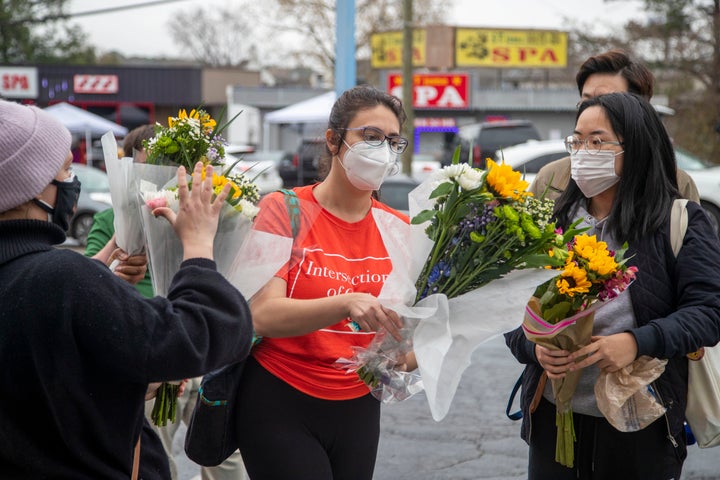 In this March 17, 2021, file photo, Roula AbiSamra, center, and Chelsey, right, prepare to lay flowers bouquets at a makeshift memorial outside of the Gold Spa in Atlanta. (Alyssa Pointer/Atlanta Journal-Constitution via AP, File)