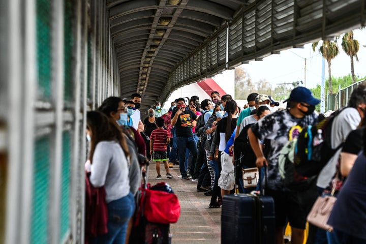 Migrants mostly form Central America wait in line to cross the border at the Gateway International Bridge into the US from Matamoros, Mexico to Brownsville, Texas, on March 15.