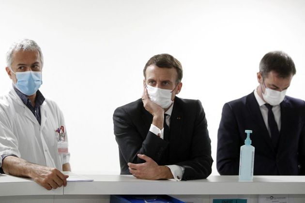 Le président Emmanuel Macron et le ministre de la Santé Olivier Véran s'entretiennent avec le chef du service de réanimation le docteur Jan Hayon et le personnel soignant du service de réanimation de l'hôpital de Poissy Saint-Germain-en-Laye, à Poissy, près de Paris, le 17 mars 2021. (Photo by YOAN VALAT/POOL/AFP via Getty Images)