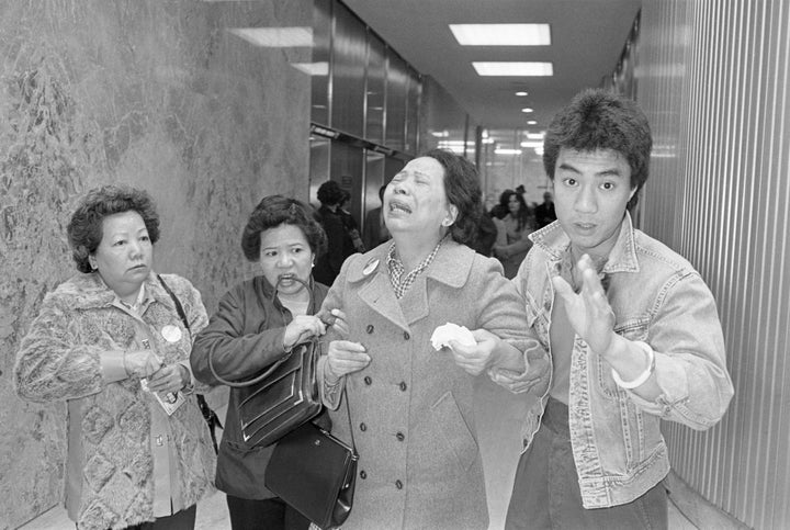 A relative, left, helps Lily Chin (center) leave Detroit's City-County Building after two white autoworkers beat her son, Vin