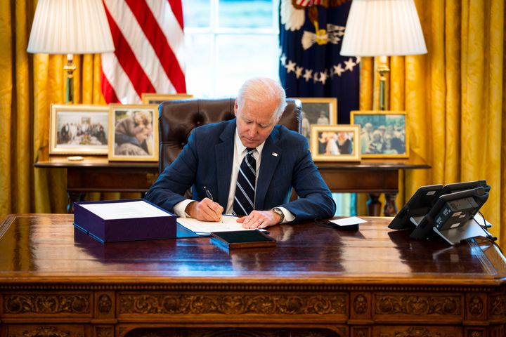 President Joe Biden signs the American Rescue Act bill into law in the Oval Office of the White House on March 11 in Washington, D.C.