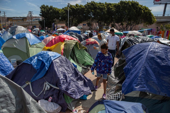 A child walks through tents at a migrant camp on the grounds of the National Institute for Migration near the "El Chaparral" border crossing in Tijuana, Mexico, on March 17. 