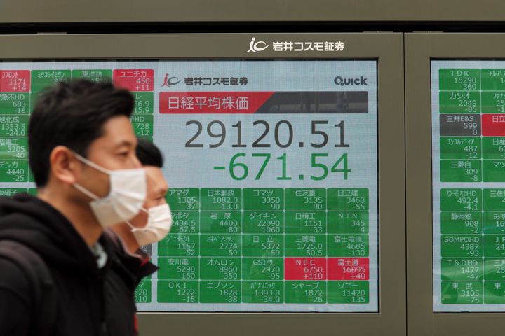 Pedestrians walk past an electronic quotation board displaying share prices of the Tokyo Stock Exchange in Tokyo on March 22, 2021. (Photo by Kazuhiro NOGI / AFP) (Photo by KAZUHIRO NOGI/AFP via Getty Images)