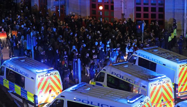 Riot police, with police horses and police vehicles, move down Rupert Street in Bristol towards protesters. 