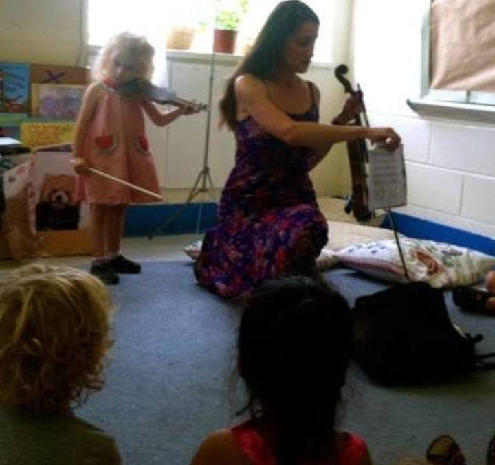 The author and one of her daughters teaching a violin class.