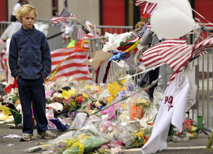 A boy visits a make-shift memorial on Boylston Street near the scene of Boston Marathon explosions in 2013. 